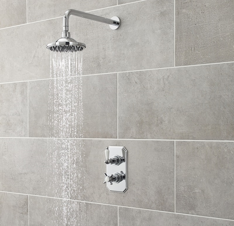 water flowing from a round shower head with chrome arm