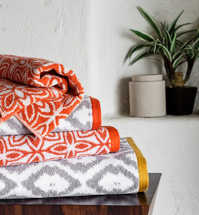 Orange and white and white and grey towels stacked up