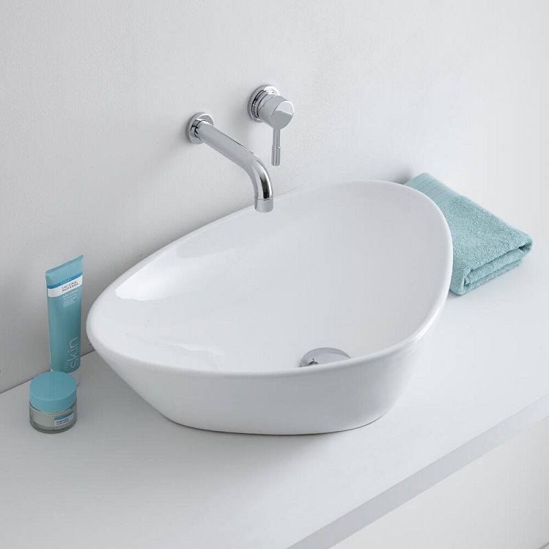 Curved triangular shaped counter top basin with wall mounted tap