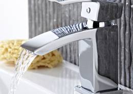 modern chrome basin tap with water pouring from spout
