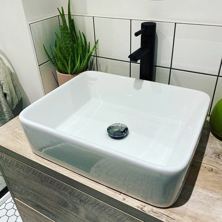 close up of white basin and black tap