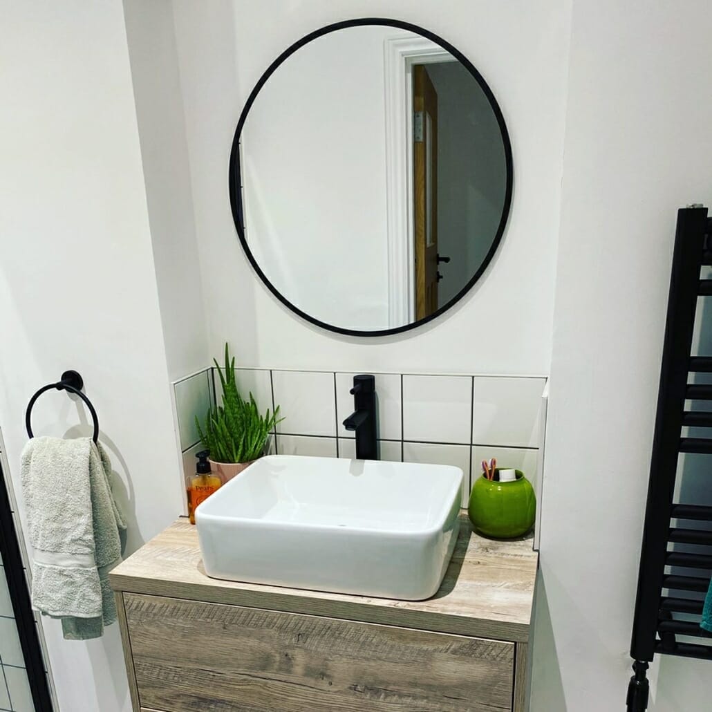a small bathroom basin and vanity unit with a black tap