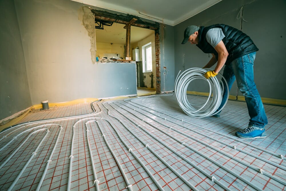 a plumber installing underfloor heating pipework