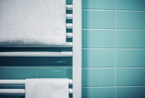 a close up of a bathroom towel radiator with towels draped over it