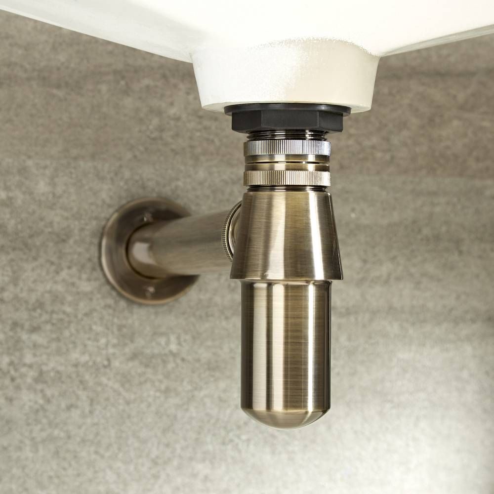 brushed gold p-trap under a small bathroom basin