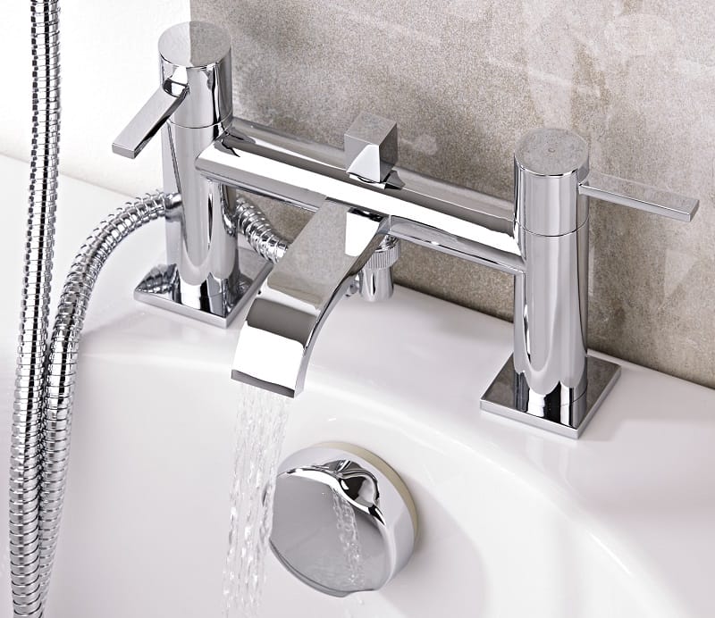 chrome bath tap with-water pouring from spout