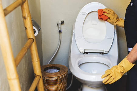 housekeeper cleaning a toilet