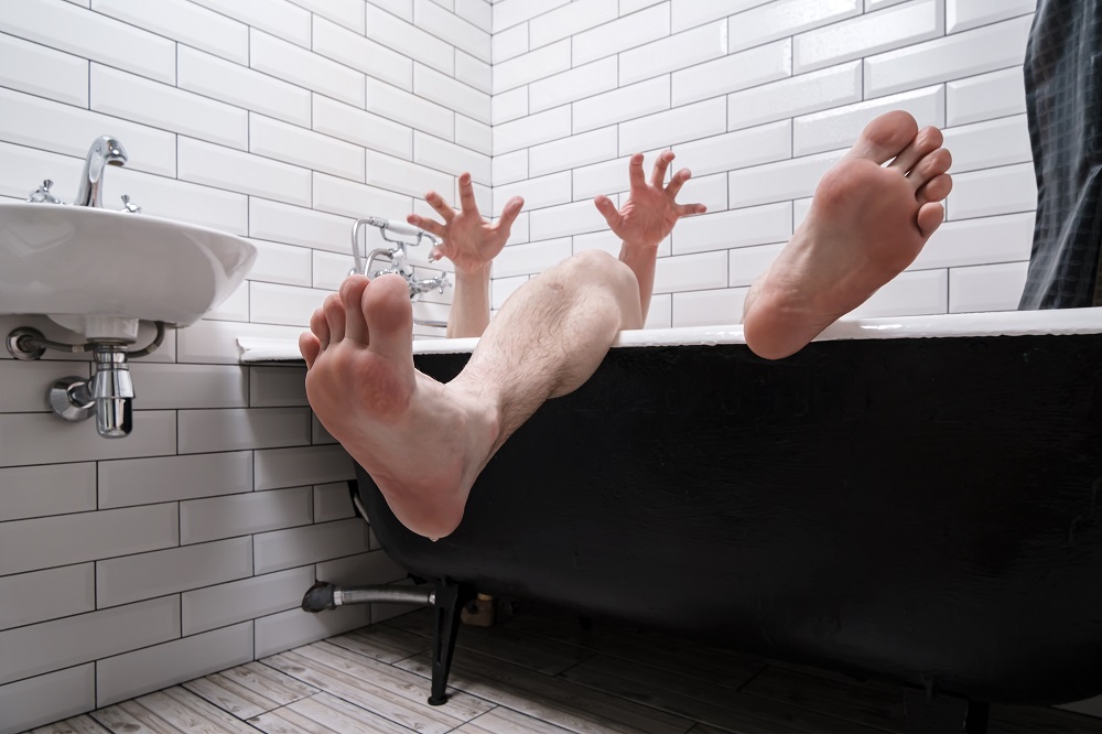 man lying in bath after falling in when wet